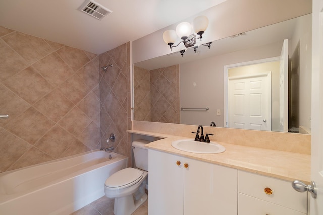 full bathroom featuring tile flooring, toilet, tiled shower / bath, and vanity with extensive cabinet space