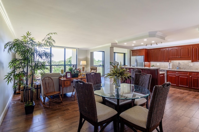 dining room featuring dark hardwood / wood-style floors, crown molding, and sink