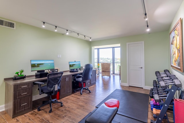 office area with light wood-type flooring and rail lighting