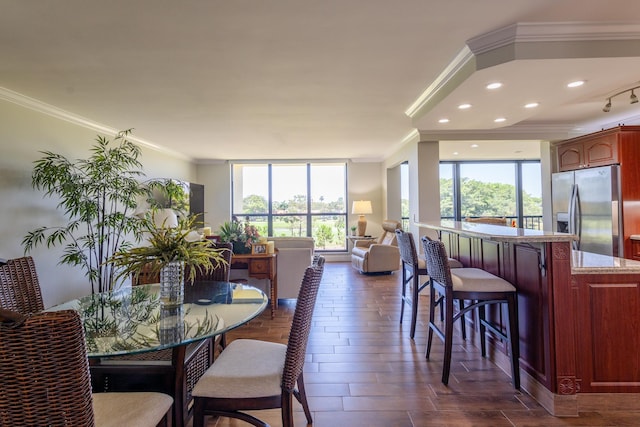 dining space with crown molding and dark wood-type flooring