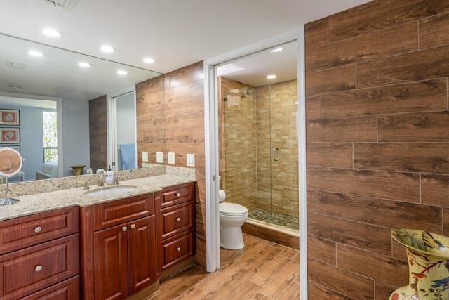 bathroom featuring hardwood / wood-style floors, vanity, toilet, and an enclosed shower