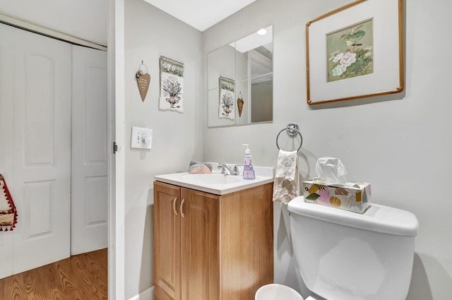 bathroom with hardwood / wood-style floors, vanity, and toilet