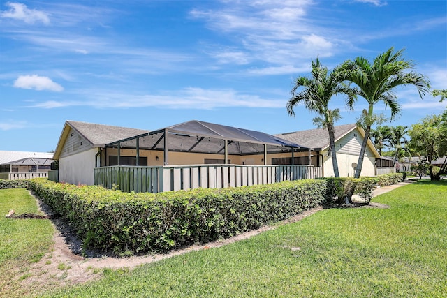 view of side of home with a yard and a lanai