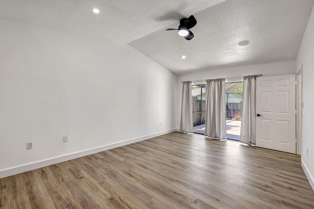 unfurnished room featuring a textured ceiling, light hardwood / wood-style floors, vaulted ceiling, and ceiling fan