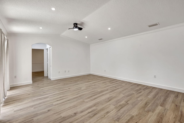 spare room with lofted ceiling, light hardwood / wood-style flooring, crown molding, and a textured ceiling