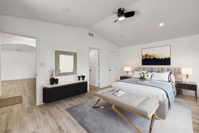 bedroom with ceiling fan, lofted ceiling, and light hardwood / wood-style flooring