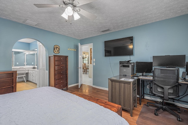 bedroom featuring a textured ceiling, wood-type flooring, and ceiling fan