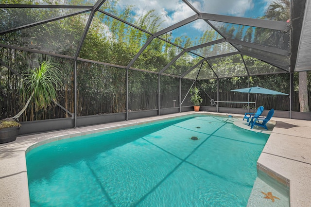 view of swimming pool featuring a patio area and a lanai