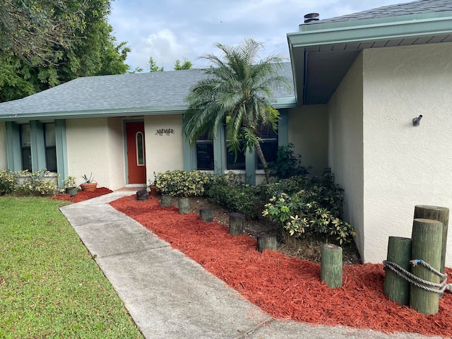 entrance to property with a lawn