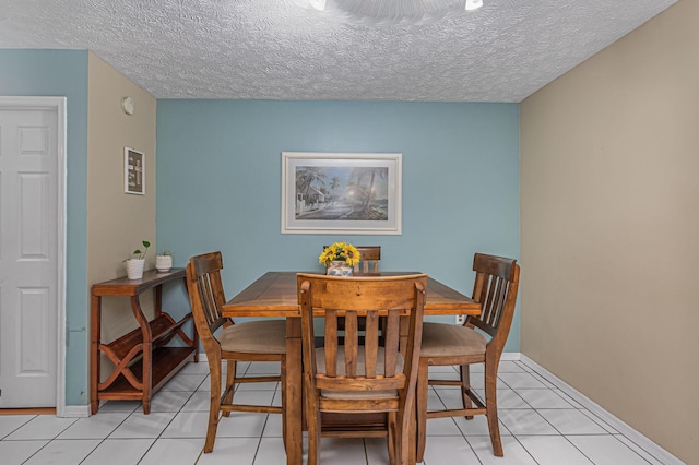 tiled dining area featuring a textured ceiling