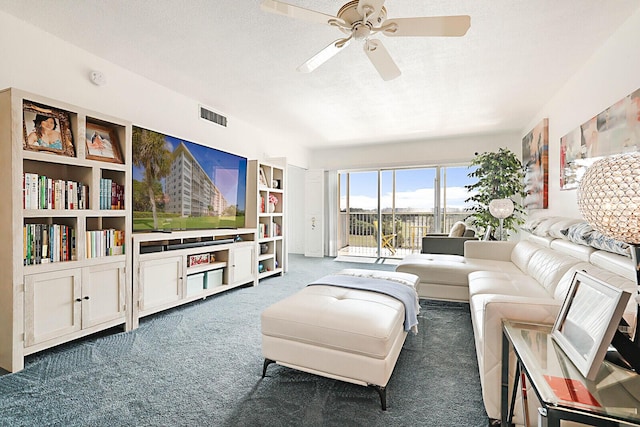 carpeted living room with ceiling fan and a textured ceiling