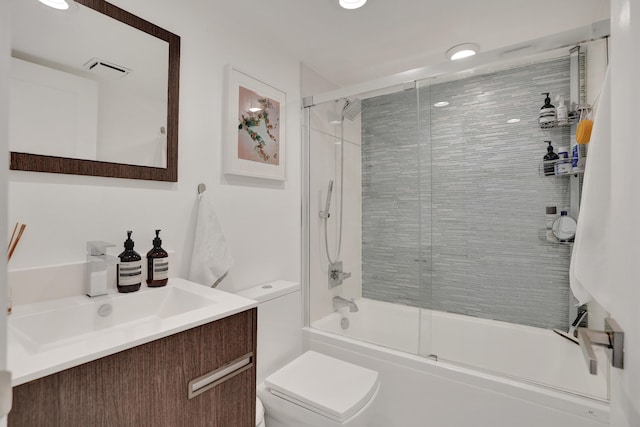 full bathroom with vanity, combined bath / shower with glass door, and toilet