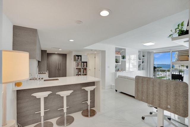 kitchen with sink, a kitchen bar, and kitchen peninsula