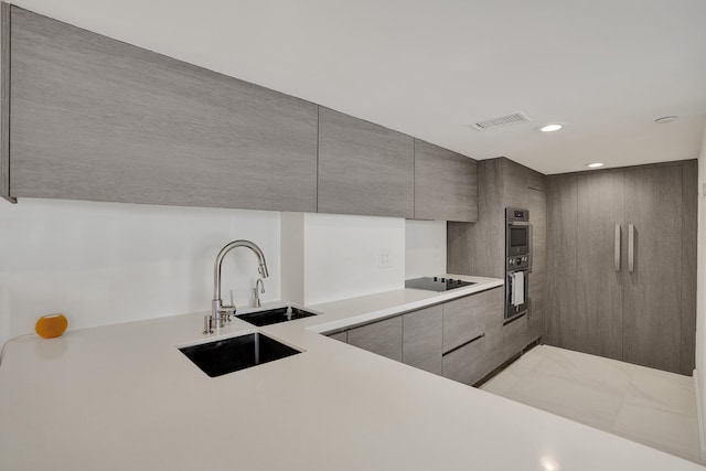 kitchen featuring black electric cooktop, sink, and double oven