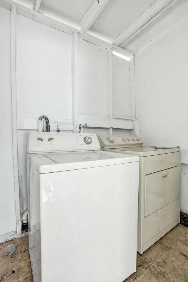 clothes washing area featuring light tile patterned floors and washer and clothes dryer