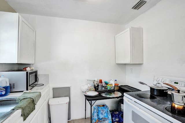 kitchen with white range with electric stovetop and white cabinetry