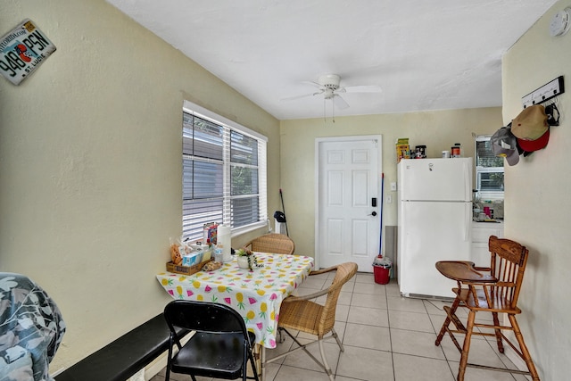 tiled dining space with ceiling fan