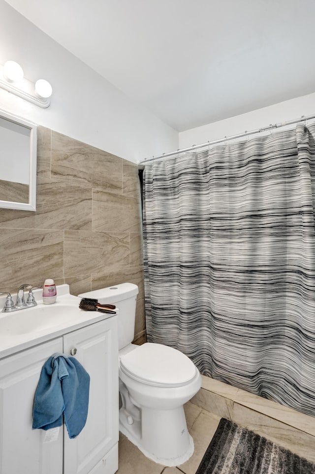 bathroom featuring tile patterned floors, a shower with curtain, sink, tile walls, and toilet