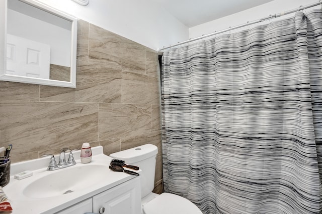 bathroom with toilet, tile walls, vanity, and curtained shower