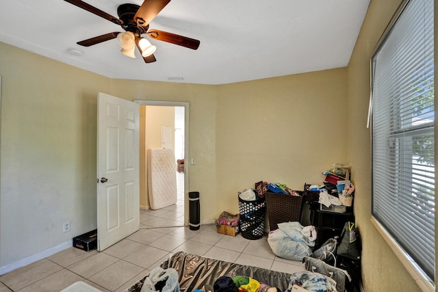 tiled bedroom featuring ceiling fan