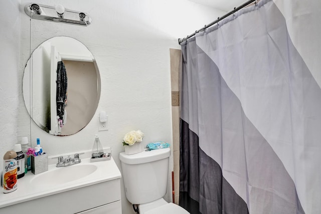 bathroom with toilet, vanity, and curtained shower