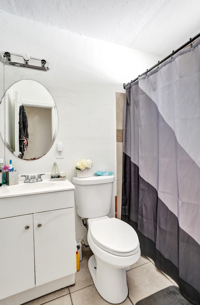 bathroom with toilet, vanity, tile patterned floors, and a textured ceiling