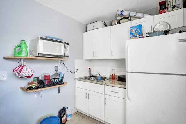 kitchen featuring sink, white appliances, white cabinets, and light tile patterned flooring