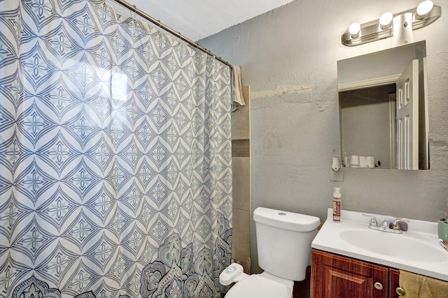 bathroom featuring toilet, vanity, and walk in shower