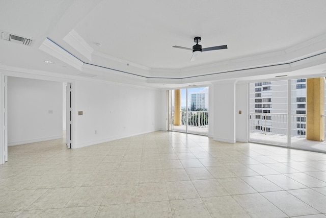 tiled empty room featuring ceiling fan, a raised ceiling, and ornamental molding