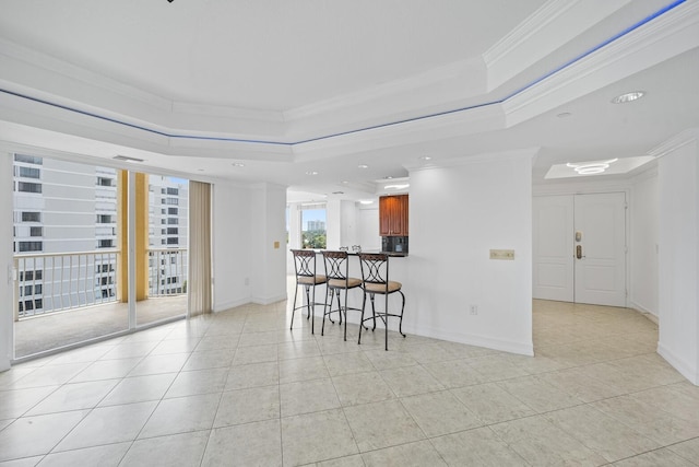 kitchen with kitchen peninsula, ornamental molding, a breakfast bar area, and light tile patterned floors