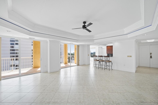 unfurnished living room with light tile patterned floors, a raised ceiling, ceiling fan, and crown molding