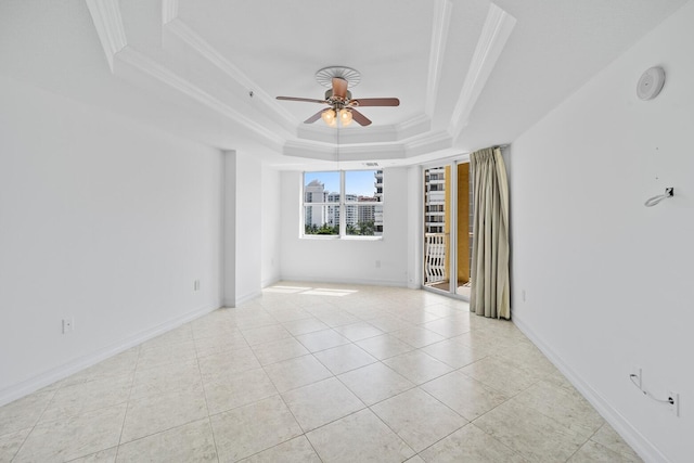 tiled empty room featuring a raised ceiling, ceiling fan, and crown molding