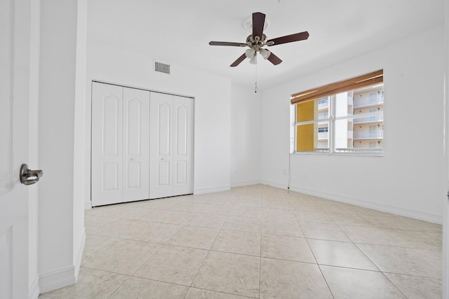 unfurnished bedroom with a closet, ceiling fan, and light tile patterned flooring