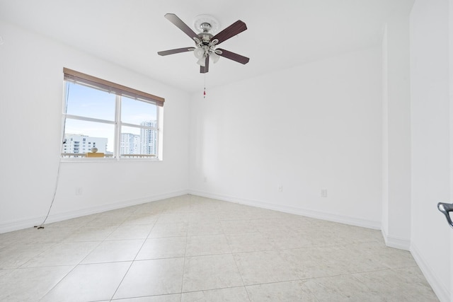 spare room with ceiling fan and light tile patterned floors