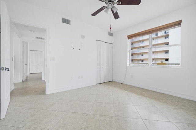 unfurnished room with light tile patterned floors and ceiling fan