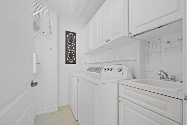 clothes washing area with washer and dryer, cabinets, light tile patterned floors, and sink