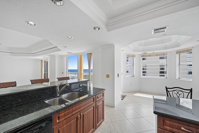 kitchen featuring a raised ceiling, crown molding, sink, dark stone countertops, and dishwasher