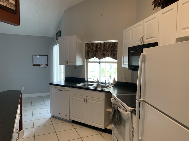 kitchen with white appliances, a textured ceiling, sink, light tile patterned floors, and white cabinets