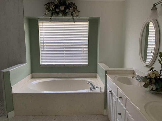 bathroom with a bathing tub, vanity, and tile patterned flooring