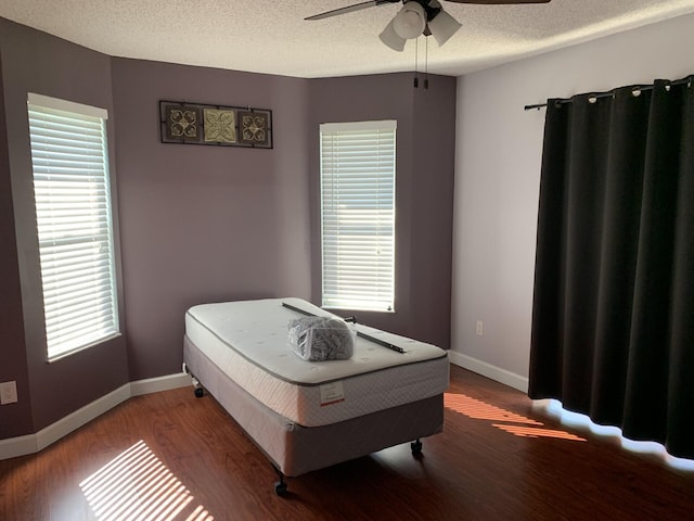 bedroom featuring ceiling fan, a textured ceiling, and hardwood / wood-style flooring