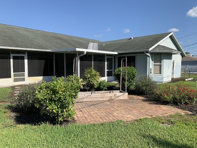 back of property featuring a sunroom and a patio area