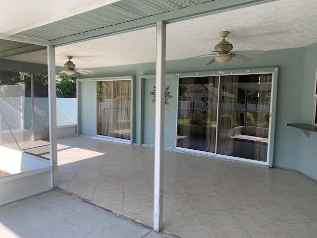 unfurnished sunroom with ceiling fan