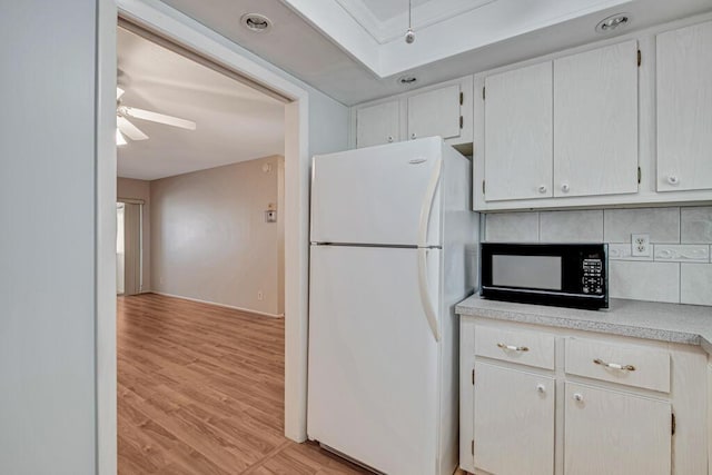 kitchen featuring tasteful backsplash, ceiling fan, white refrigerator, white cabinets, and light hardwood / wood-style floors