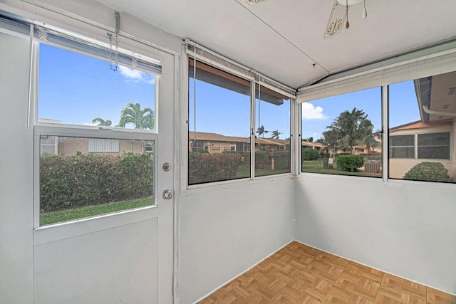 unfurnished sunroom featuring a wealth of natural light, ceiling fan, and lofted ceiling