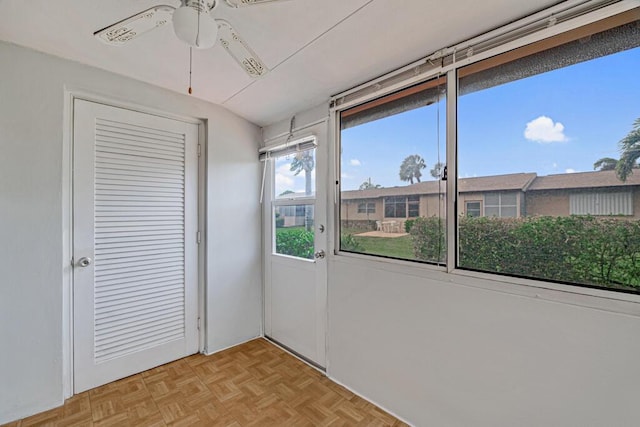 unfurnished sunroom featuring ceiling fan