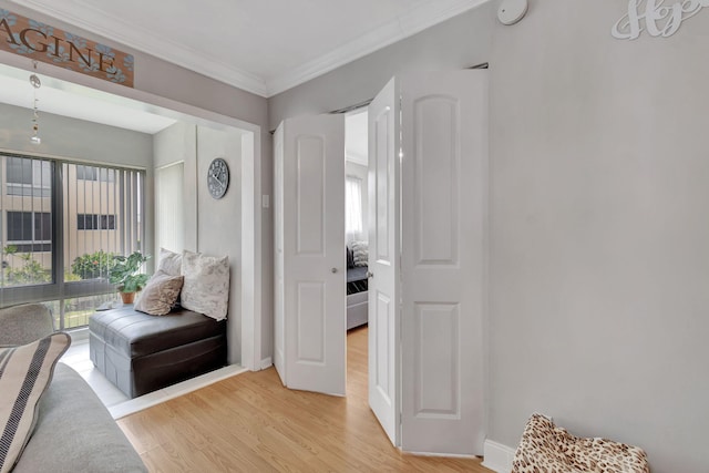 living area featuring light wood-type flooring and ornamental molding