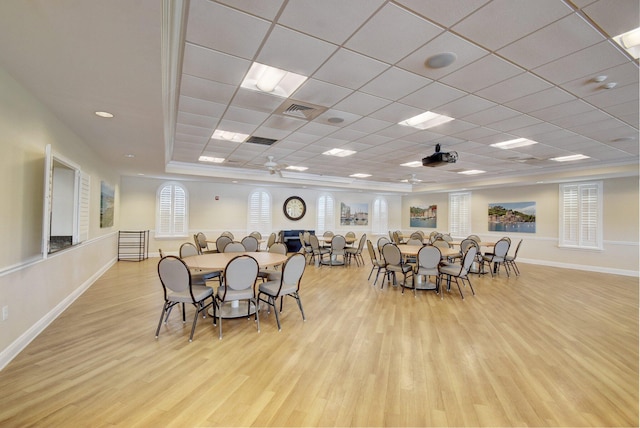 dining space featuring a drop ceiling, light hardwood / wood-style flooring, and ceiling fan