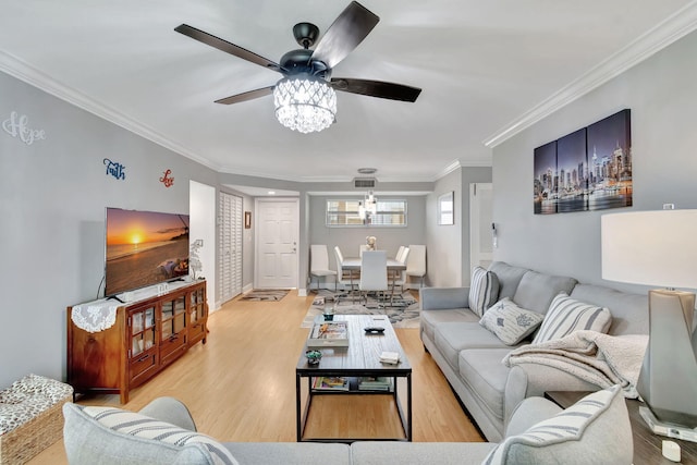 living room featuring light hardwood / wood-style flooring, ceiling fan, and crown molding