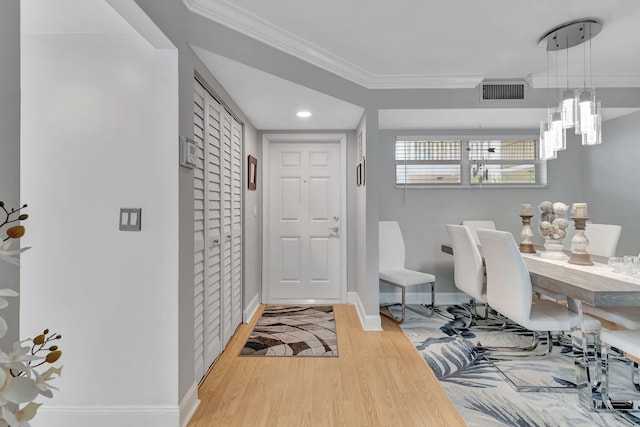 interior space with a notable chandelier, crown molding, and light hardwood / wood-style flooring