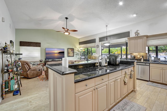 kitchen featuring stainless steel dishwasher, dark stone counters, a kitchen island with sink, decorative light fixtures, and lofted ceiling